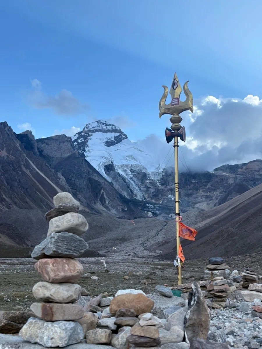 Prayer flags strung from a pole against the mountains on the Kailash circuit